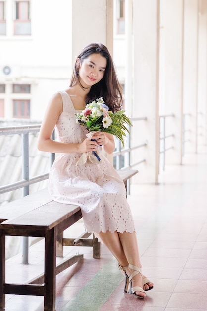 Young asian lady holding flowers in her hands