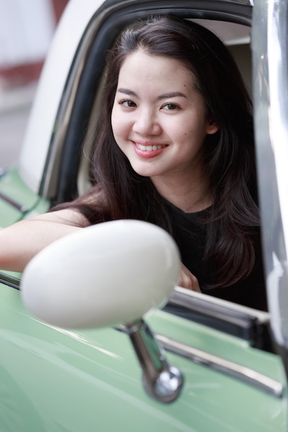 ビンテージ車の中で若いアジア女性