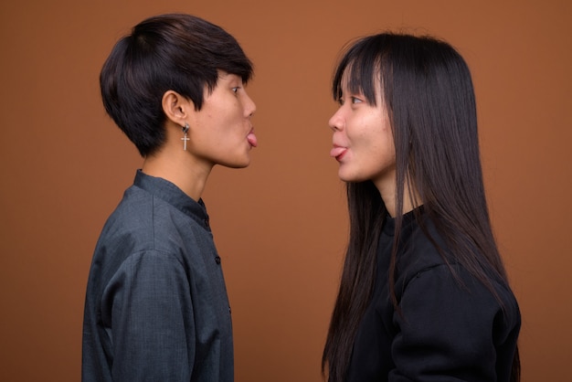 Young Asian lesbian couple together and in love against brown