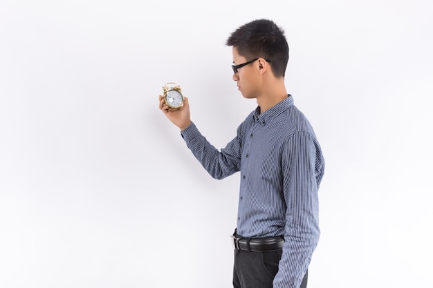 Young Asian male hands holding alarm clock in front of white background