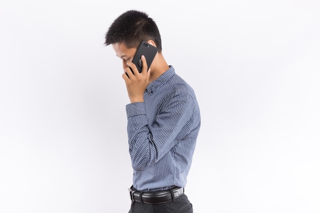 Young asian male holding cellphone in front of white background