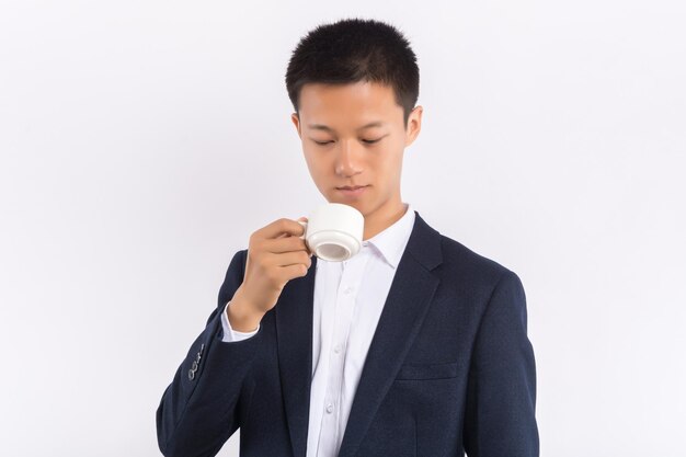 Young Asian male holding a coffee cup in his hand