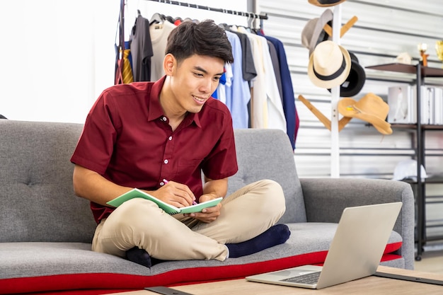 Young Asian male online merchant freelance blogger is working business at home with laptop Social media Influencer and online shopping concept