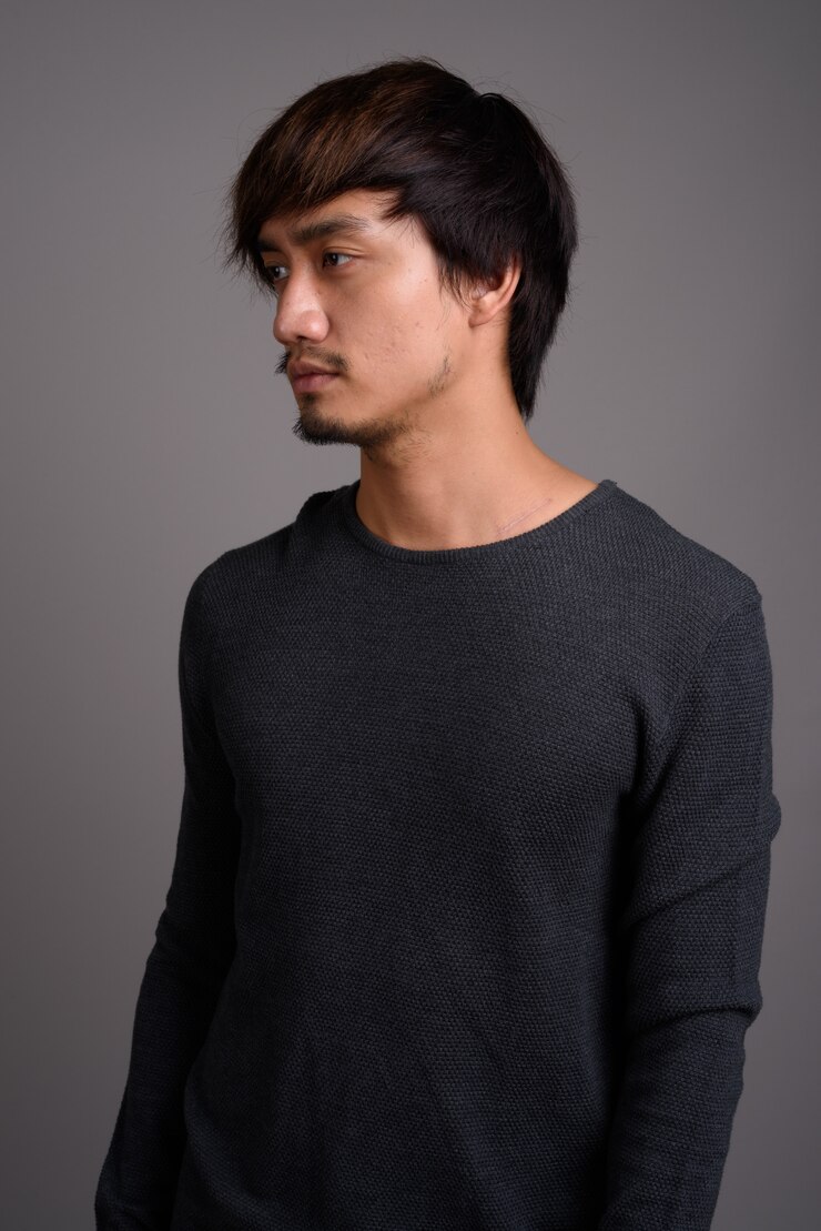 Photo 灰色の壁に対して若いアジア人