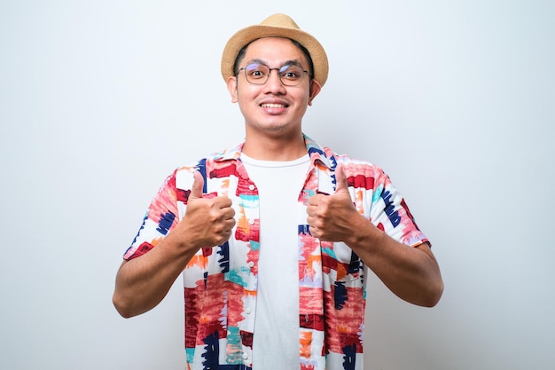 Young asian man approving doing positive gesture with hand thumbs up smiling and happy for success Winner gesture