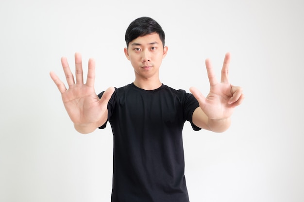 Young Asian man black shirt count one to ten by hand half body on white isolated background