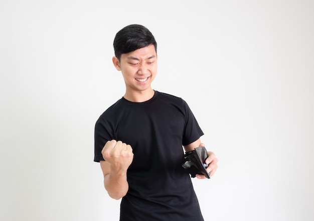 Young Asian man black shirt show fist up and happy face with money in wallet in hand