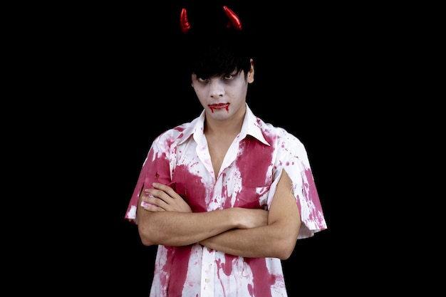 Young Asian man costume in hell, evil on black wall with concept for Halloween fashion festival. Teen Asian man in cosplay Halloween.