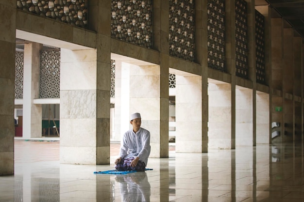 Young Asian man doing Salat on the mosque