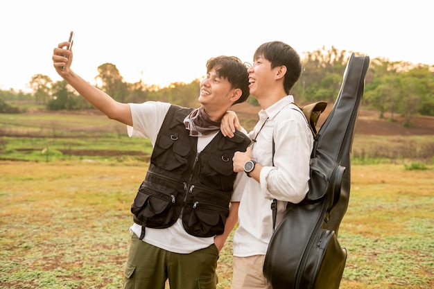 Young Asian man enjoy camping making selfie via smartphone