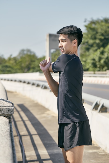 Photo young asian man exercising in the city