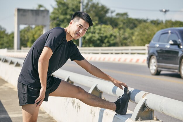 Photo young asian man exercising in the city