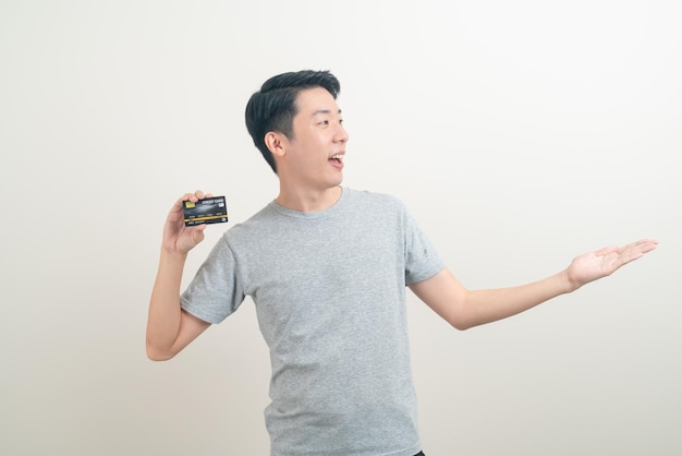 Young Asian man holding credit card