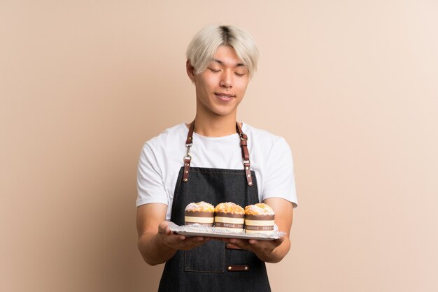 Young asian man  holding mini cakes