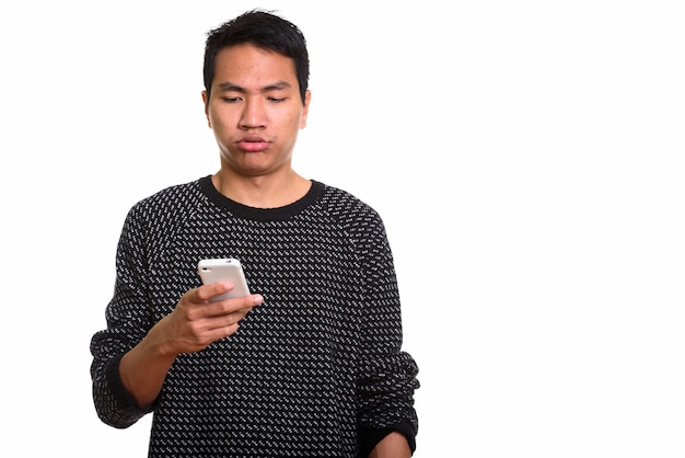 молодой азиатский мужчина держит телефон, выглядя усталым