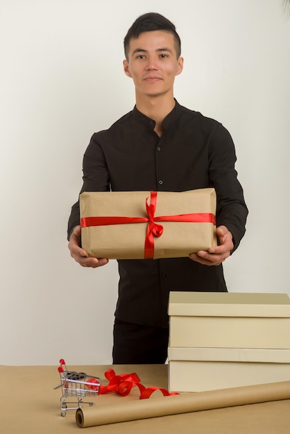 Young Asian man holds a gift parcel in hands Image