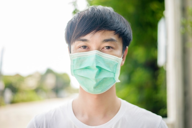 Young Asian man is wearing face mask in City outdoor