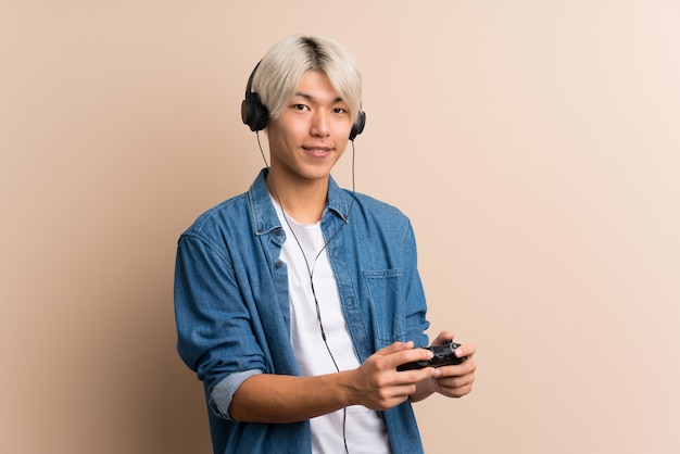 Young asian man over isolated playing at videogames