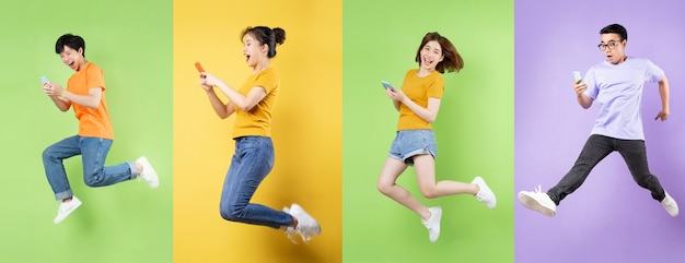 Young asian man jumping  isolated on green background