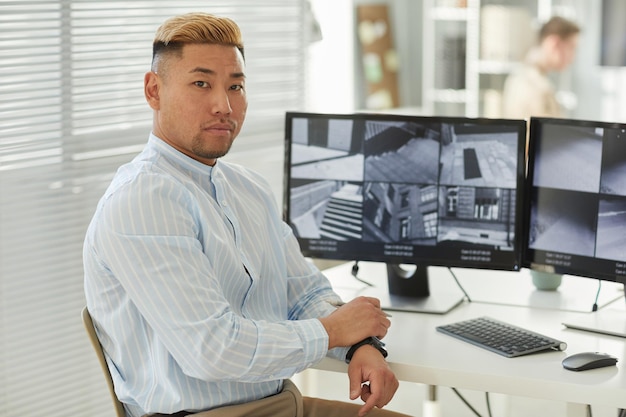 Young Asian man looking at camera with surveillance