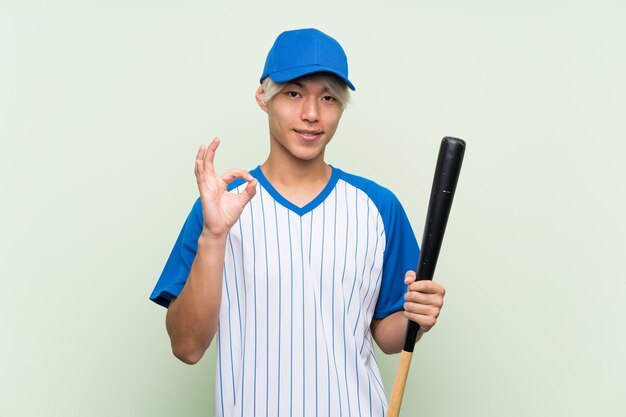 Young asian man playing baseball  showing ok sign with fingers