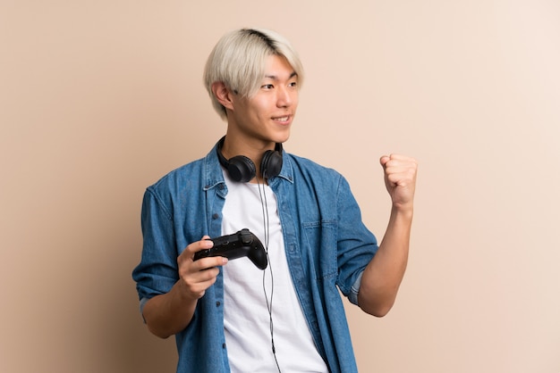 Young asian man playing at videogames