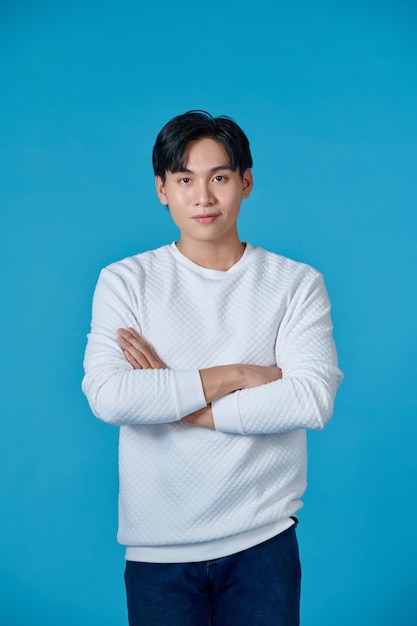 Photo young asian man posing on a blue background