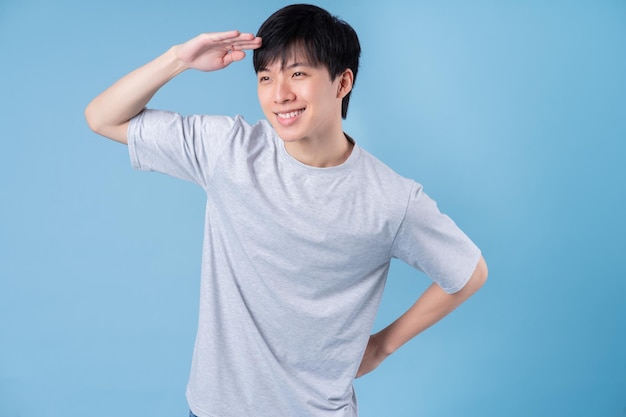 Young Asian man posing on blue background