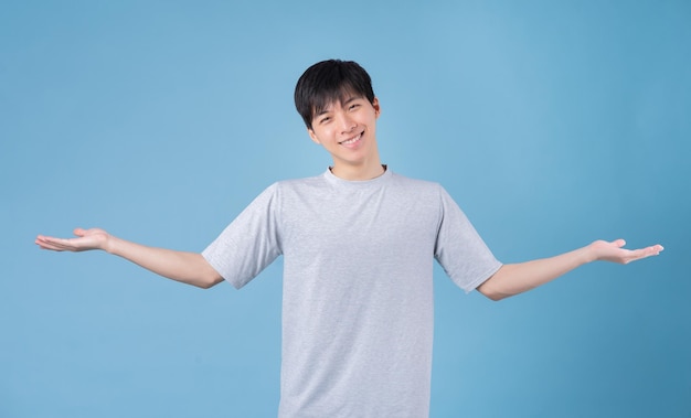 Young Asian man posing on blue background