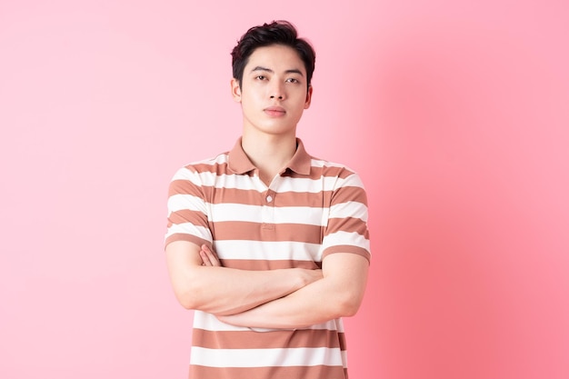 Young Asian man posing on pink background