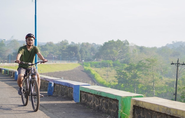 若いアジア人男性は朝自転車に乗る