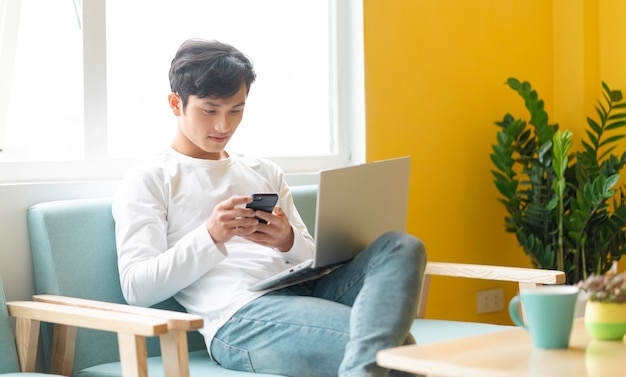 Young Asian man sitting working at home