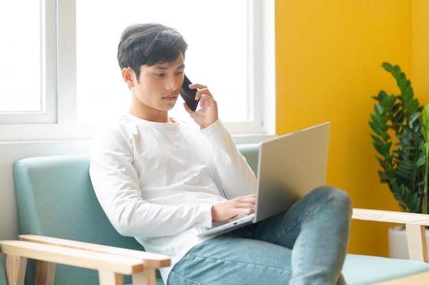 Young Asian man sitting working at home