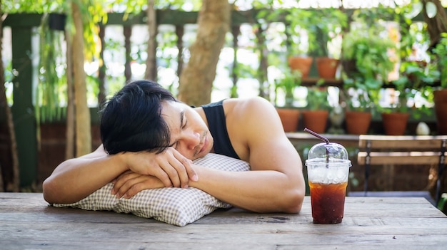 Young Asian man sleeping in a garden.