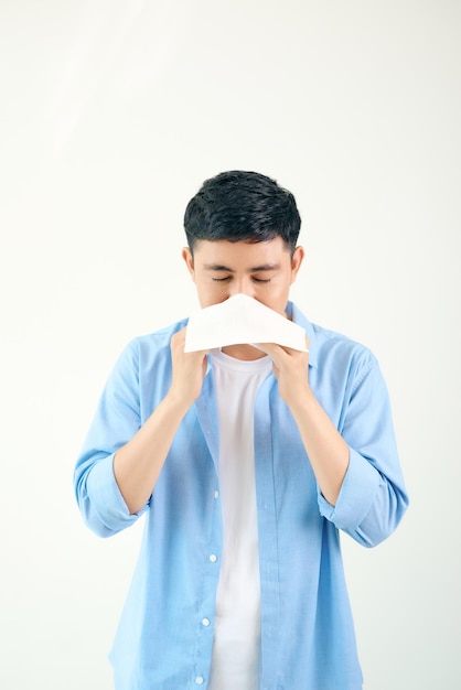 Young asian man sneezing after get allergy or flu virus and using tissue paper for swipe on nose at medical clinic after got coronavirus covid19 disease for unhealthy lifestyle concept