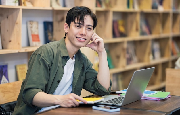 Young Asian man studying at library