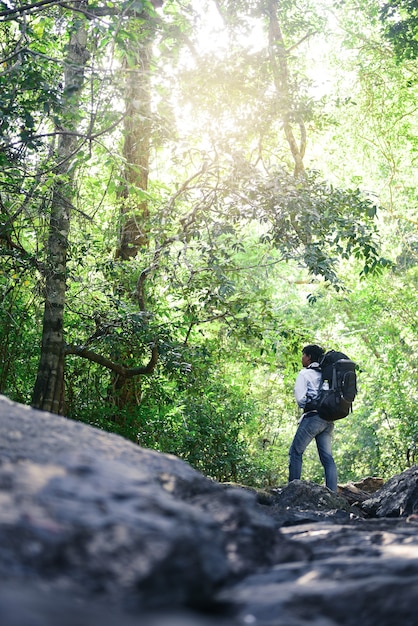 写真 タイの山で写真を撮るバックパックを持つ若いアジア人男性旅行者。