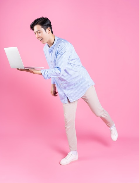 백그라운드에서 노트북을 사용하는 젊은 아시아 남자
