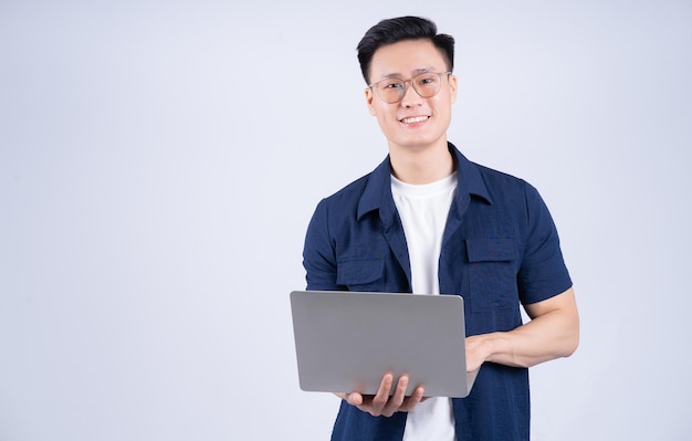 Young Asian man using laptop on white background