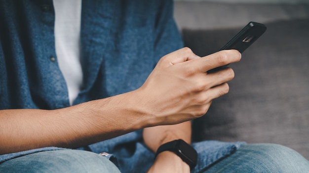 Young Asian man using smartphone typing, chatting conversation. Social Network, technology concept.