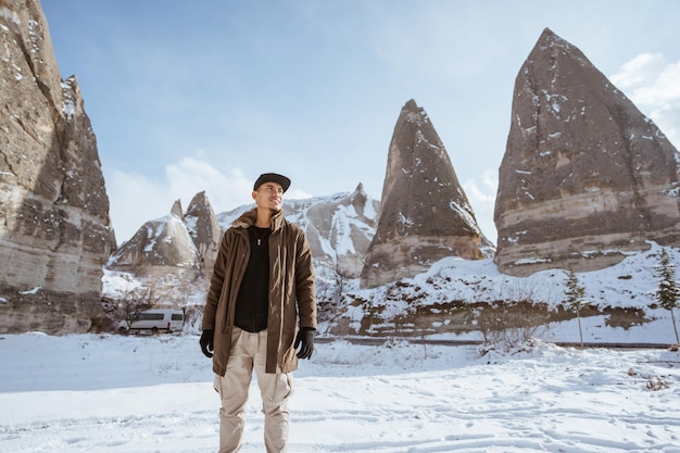 Young asian man walking alone in beautiful snowy landscape