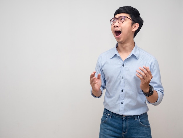 Young asian man wear glasses gesture amazed looking at copy space