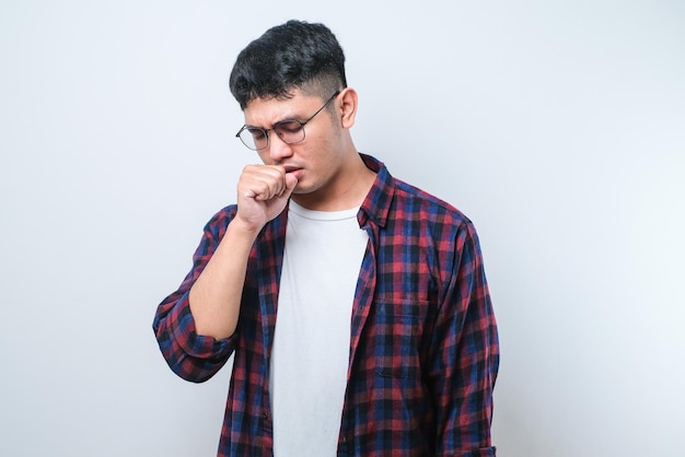 Young asian man wearing casual shirt and glasses coughing with sore throat concept of man with allergy