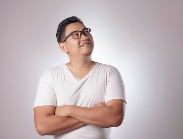 Young Asian man wearing casual white shirt thinking smiling expression Close up body portrait