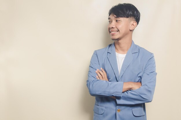 Young asian man wearing college suit showing empty space on isolated background