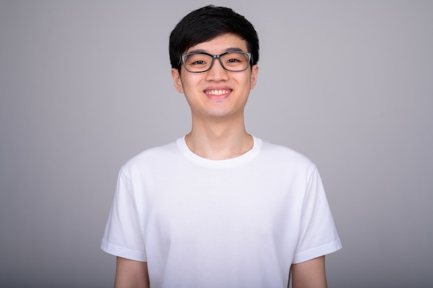 young Asian man wearing eyeglasses on white