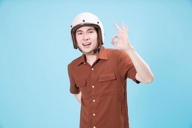 Young Asian man wearing helmet on background