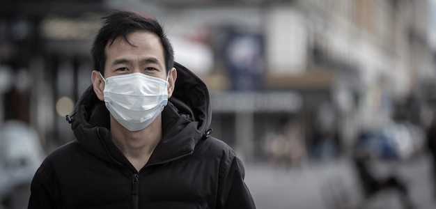 young asian man wearing a mask to prevent germs, toxic fumes, and dust