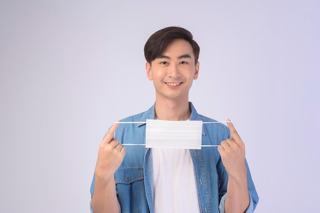 Young asian man wearing protective mask over white background studio