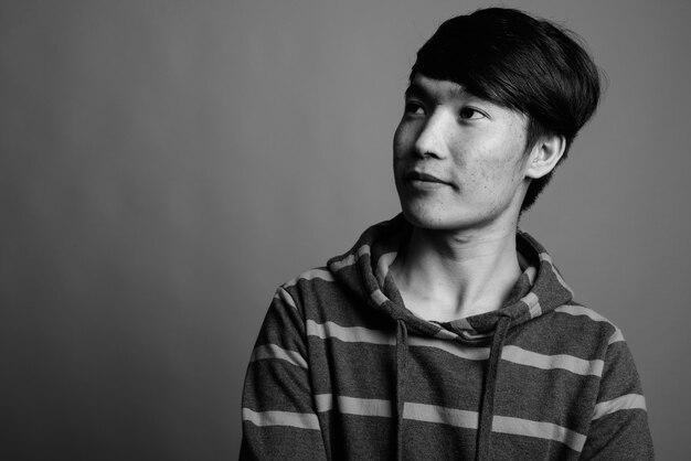 Young Asian man wearing striped hoodie